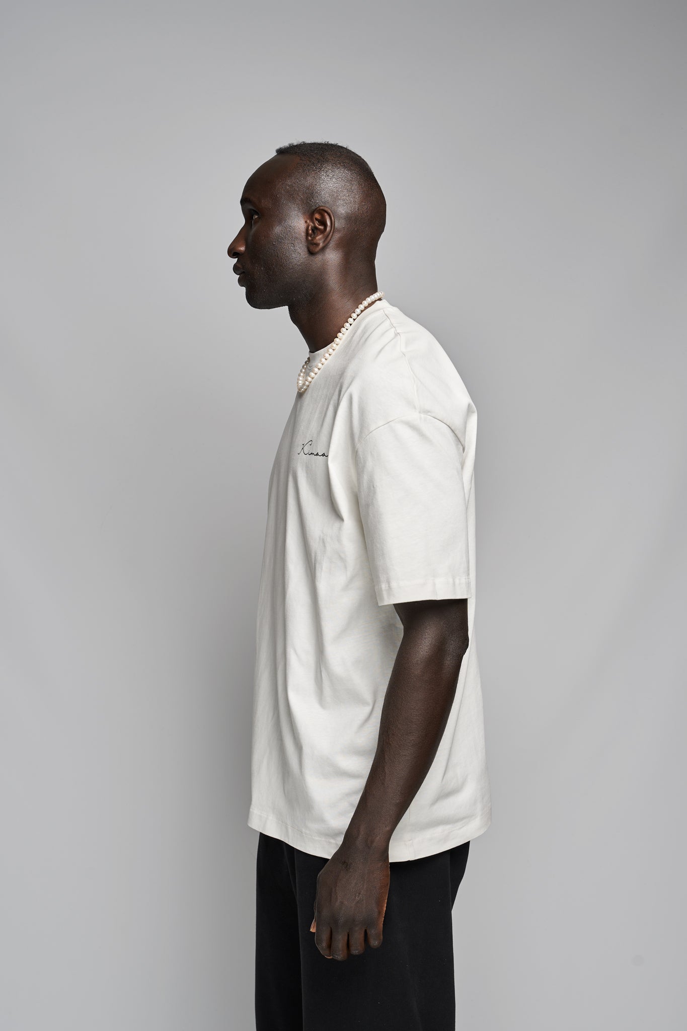 Side view of model in Kimaa’s Bankoo beige tee — heavyweight organic cotton with calm, earthy tones.