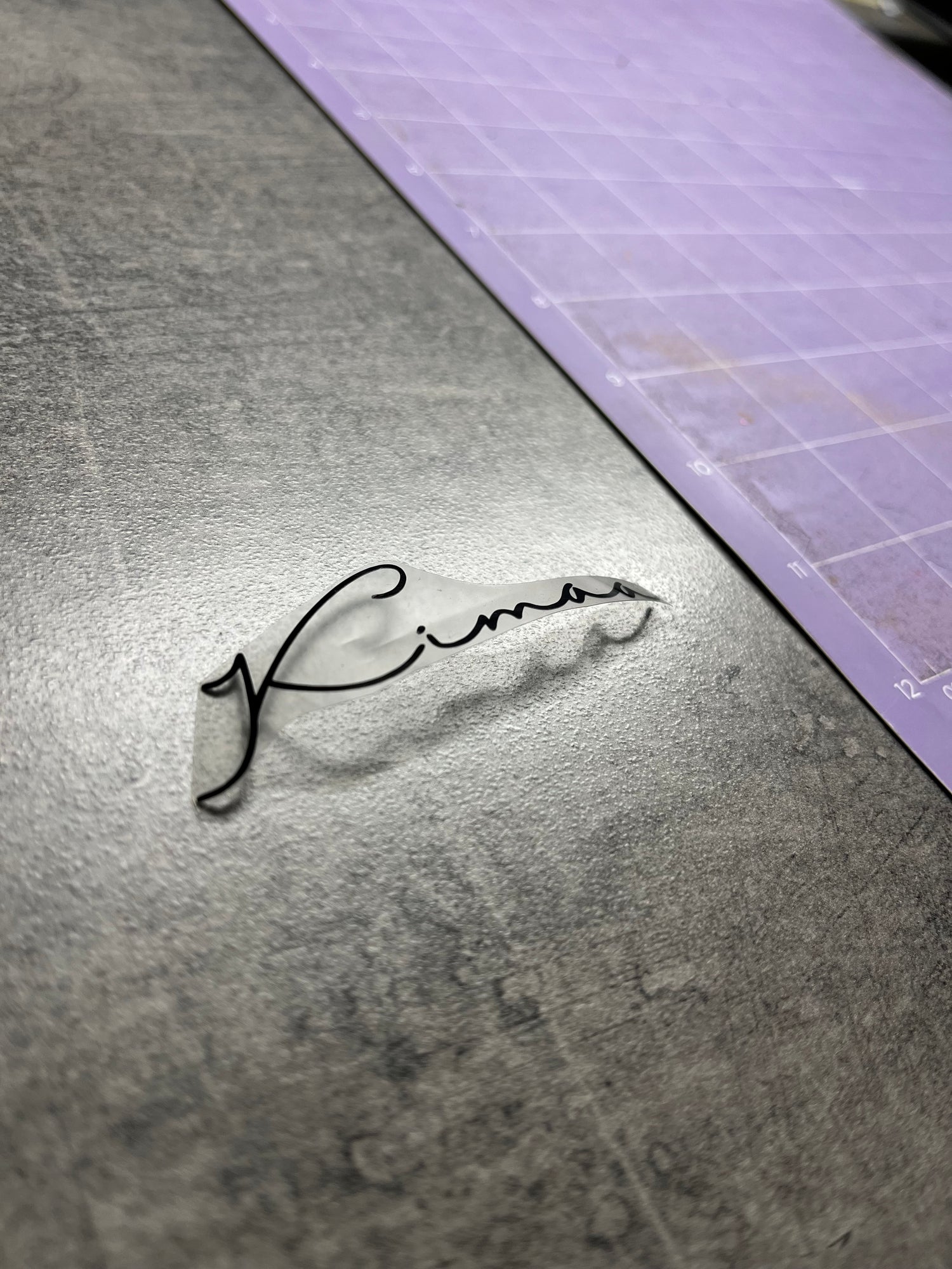 Kimaa Collective logo in pre-production stage, shown on print film before garment application