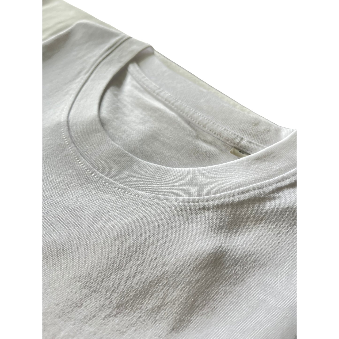 Closeup of neckline stitching on Kimaa’s Senumaa white organic cotton T-shirt, highlighting quality.
