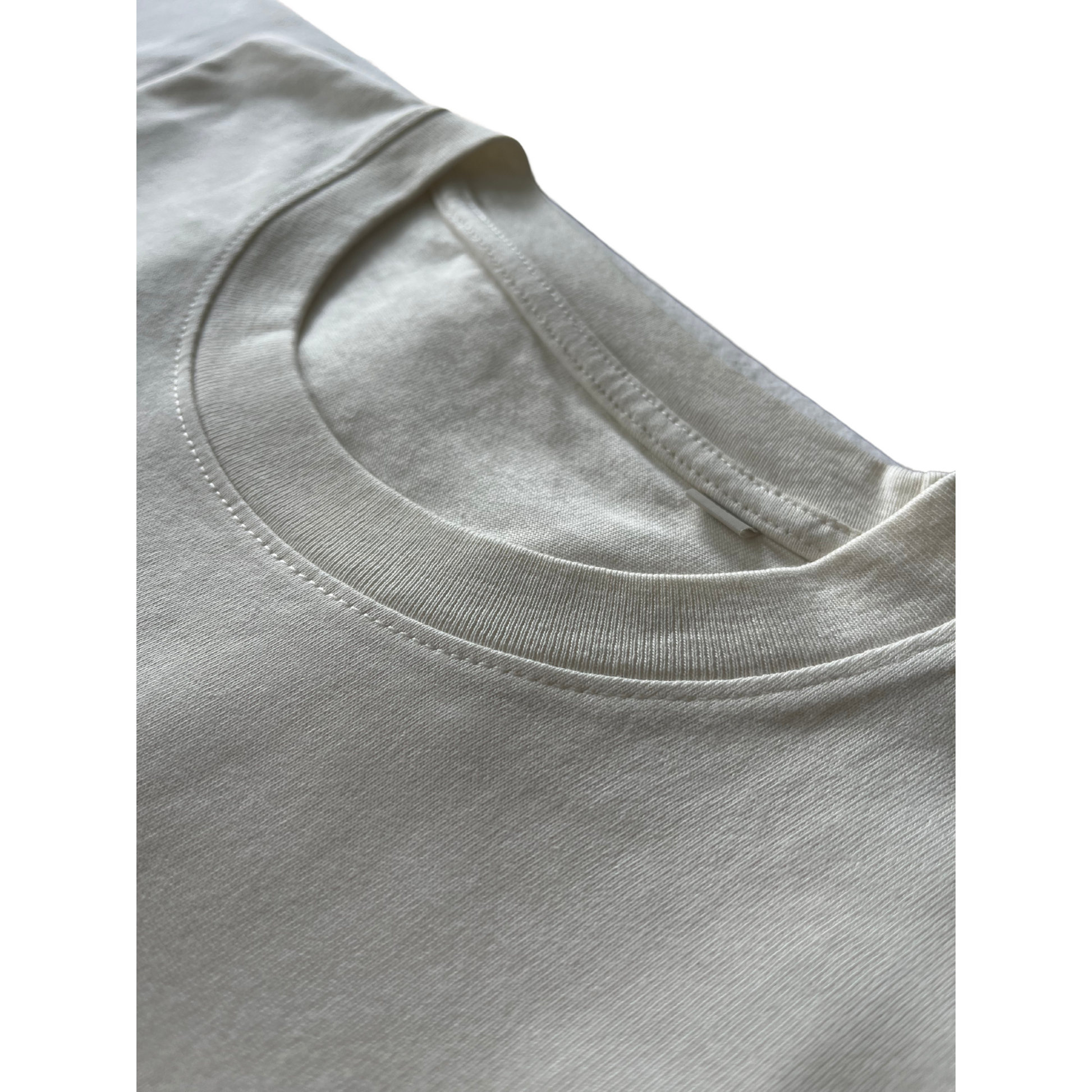 Closeup of neckline stitching on Kimaa’s Bankoo beige organic cotton T-shirt — ethical and durable.