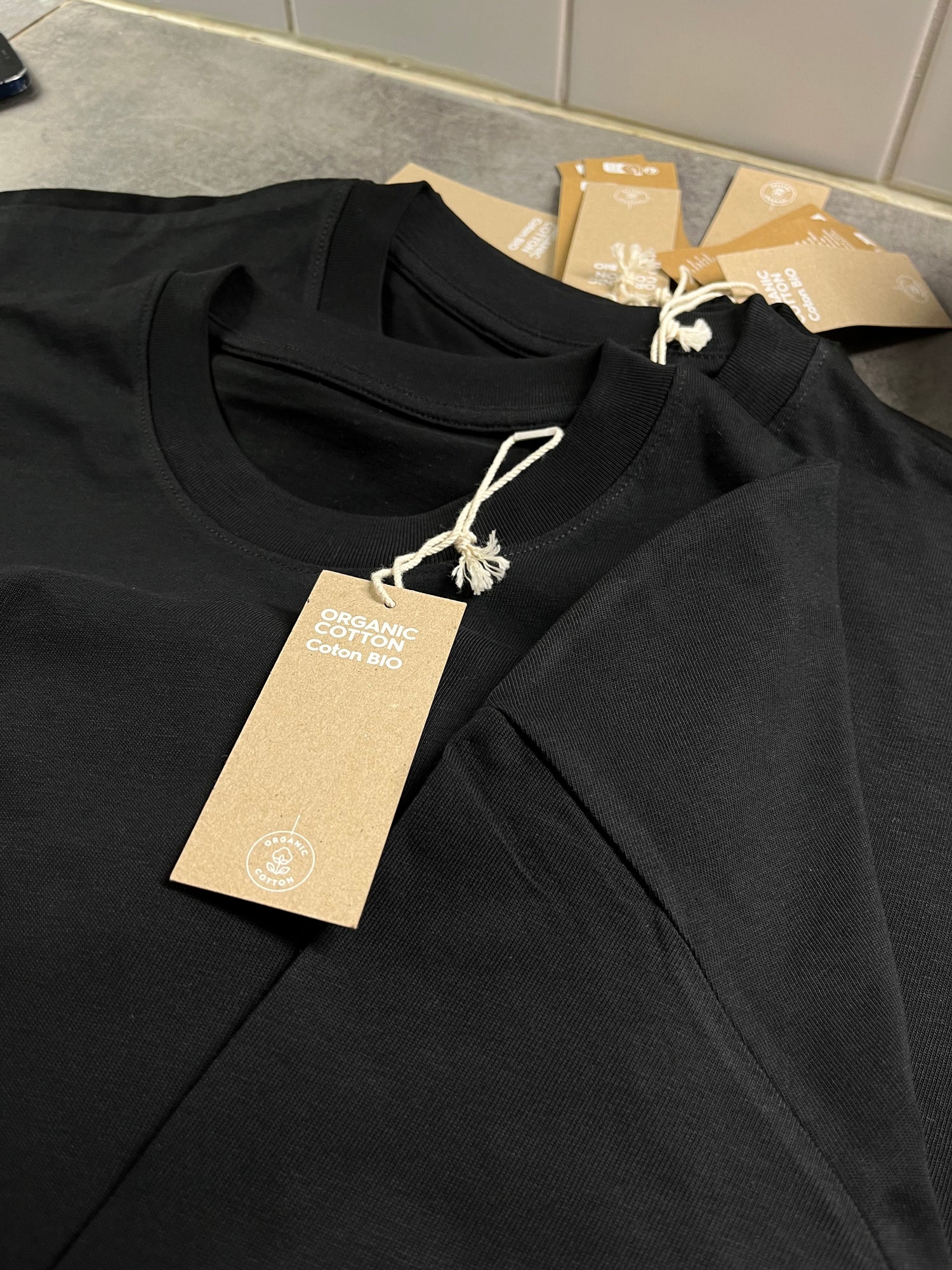 Close-up of organic cotton label on a black sustainable T-shirt by Kimaa Collective