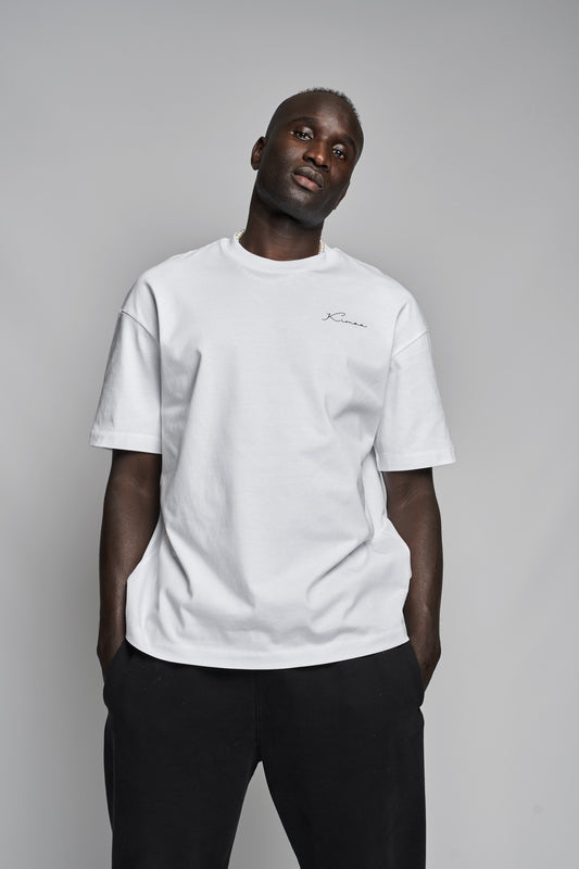 Model wearing Senumaa white organic cotton T-shirt from the front, relaxed fit Afro-Nordic style.