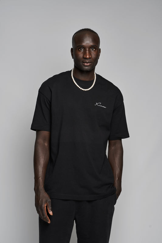 Model wearing Suutoo black organic cotton T-shirt by Kimaa, front view, relaxed fit