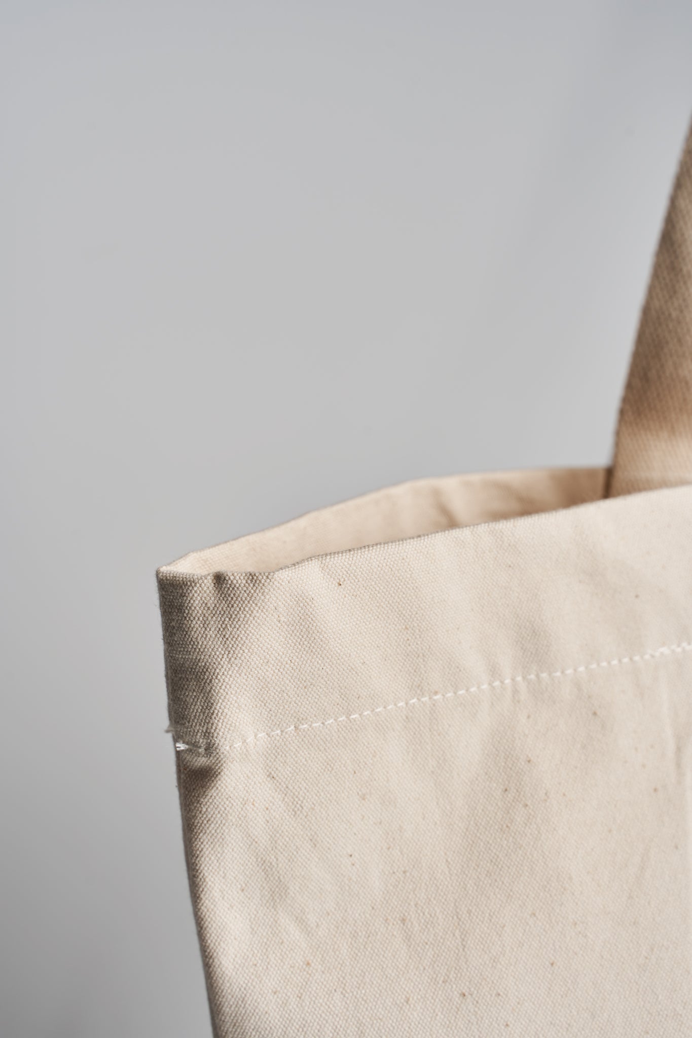 Closeup of stitching and top edge finish of the Taamoo organic cotton tote bag.
